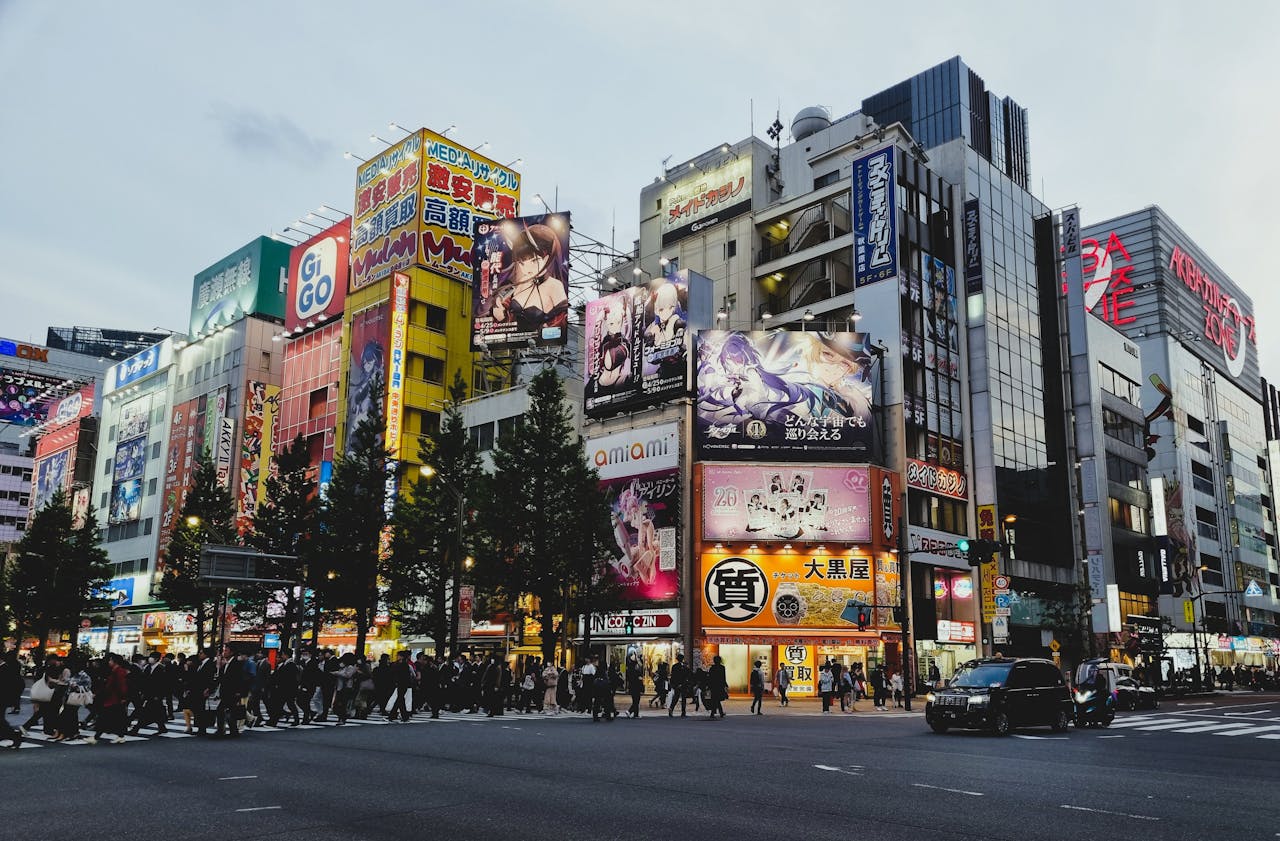 Captivating evening city scene in Akihabara, Tokyo showcasing bright lights, bustling streets, and iconic billboards.